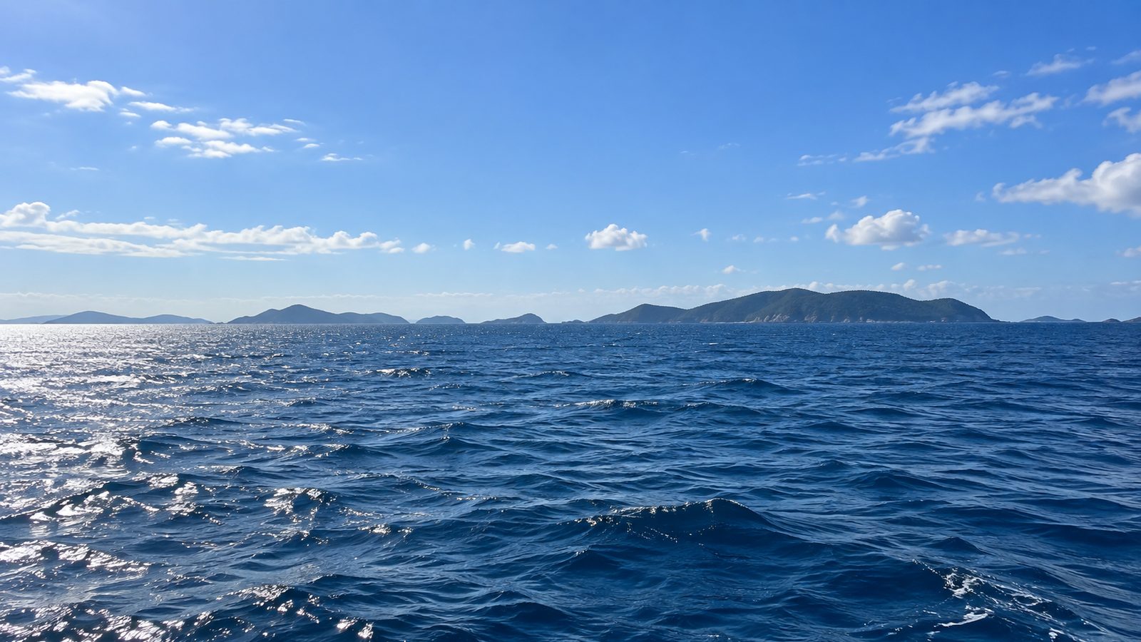 沖から見た響灘の島影と水平線、青空